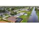 Aerial shot of the waterfront neighborhood with manicured lawns and screened lanais, showcasing a tranquil residential community at 104 Mark Twain Ln, Rotonda West, FL 33947
