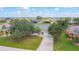 Wide aerial shot of a well-kept property, emphasizing the lawn, front yard, and neighborhood layout with a golf course at 104 Mark Twain Ln, Rotonda West, FL 33947