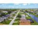 Neighborhood aerial showcasing a canal-front community with tidy lawns and screened patios, offering peaceful waterfront living at 104 Mark Twain Ln, Rotonda West, FL 33947