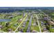 Expansive aerial view of a residential community featuring lush green lawns and waterfront properties along a canal at 104 Mark Twain Ln, Rotonda West, FL 33947
