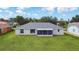 The back exterior features a screened-in patio and a spacious lawn at 104 Mark Twain Ln, Rotonda West, FL 33947