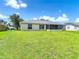 The back exterior features a screened-in patio and a spacious lawn at 104 Mark Twain Ln, Rotonda West, FL 33947