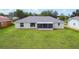 The back exterior features a screened-in patio and a spacious lawn at 104 Mark Twain Ln, Rotonda West, FL 33947
