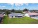 Well-maintained backyard featuring a screened-in lanai and lush green lawn, perfect for outdoor relaxation and entertaining at 104 Mark Twain Ln, Rotonda West, FL 33947