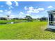 Expansive backyard featuring a scenic canal view, lush lawn, and a screened-in patio at 104 Mark Twain Ln, Rotonda West, FL 33947