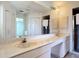 Large bathroom features a long vanity, a ceiling fan and two sinks at 104 Mark Twain Ln, Rotonda West, FL 33947