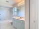 Bright bathroom features a blue vanity, a tub/shower combo, and decorative floor tiles at 104 Mark Twain Ln, Rotonda West, FL 33947