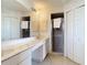 Well-lit bathroom with a long vanity, two sinks, and a tiled shower at 104 Mark Twain Ln, Rotonda West, FL 33947