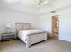 Cozy bedroom featuring neutral colors, a ceiling fan and a glimpse into the bathroom at 104 Mark Twain Ln, Rotonda West, FL 33947