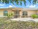 Close up of the home's entrance featuring a screened door, stone landscaping, and a well maintained lawn at 104 Mark Twain Ln, Rotonda West, FL 33947