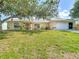 Inviting single-Gathering house with manicured front lawn, a paved driveway, and an attached two-car garage at 104 Mark Twain Ln, Rotonda West, FL 33947