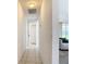 Hallway with tile flooring leads to rooms and living area; bright and airy at 104 Mark Twain Ln, Rotonda West, FL 33947