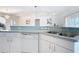 Kitchen featuring white cabinets, tile flooring, a dishwasher, and a sink with a view into the living space at 104 Mark Twain Ln, Rotonda West, FL 33947