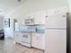Functional kitchen with white appliances, ample cabinet space, and an easy-to-clean tile floor at 104 Mark Twain Ln, Rotonda West, FL 33947