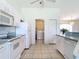 Well-lit kitchen with appliances and washer/dryer through doorway; ample storage and tile floor at 104 Mark Twain Ln, Rotonda West, FL 33947