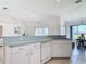 View of the kitchen area showcasing white cabinets, countertops, and tile flooring at 104 Mark Twain Ln, Rotonda West, FL 33947