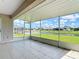 A screened-in lanai providing scenic views of the waterfront, neighboring pool, and lush green landscape at 104 Mark Twain Ln, Rotonda West, FL 33947