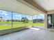 Screened-in lanai offering serene views of the lush backyard, pond, and neighboring homes at 104 Mark Twain Ln, Rotonda West, FL 33947