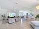 Spacious living room with tile floors, large windows offering water views, and modern neutral-toned furnishings at 104 Mark Twain Ln, Rotonda West, FL 33947