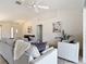 Bright living room with tile flooring, neutral-toned furniture, and access to other areas of the house at 104 Mark Twain Ln, Rotonda West, FL 33947