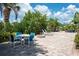 Expansive backyard with brick pavers, patio furniture, lush tropical landscaping, and a cozy fire pit at 1060 Haste Ln, Englewood, FL 34223
