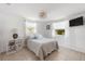 Cozy bedroom features a comfortable bed with decorative pillows, soft window treatments, and a modern light fixture at 1060 Haste Ln, Englewood, FL 34223