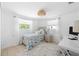 Bright bedroom with a single bed, white walls, desk, and two windows offering plenty of natural light at 1060 Haste Ln, Englewood, FL 34223