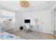 Bright bedroom with a single bed, white walls, desk, and a neutral rug at 1060 Haste Ln, Englewood, FL 34223