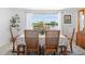 A dining table set for six, positioned by a large window that provides a serene view of the canal at 1060 Haste Ln, Englewood, FL 34223