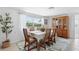 Bright dining room features a large window overlooking the outside scenery and a beautiful, cushioned, six-chair dining set at 1060 Haste Ln, Englewood, FL 34223