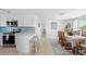 An open-concept kitchen and dining area with white cabinets and a breakfast bar that offers seating for two at 1060 Haste Ln, Englewood, FL 34223