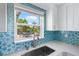 Kitchen sink framed by a window, showcasing a view of the outdoor patio and garden at 1060 Haste Ln, Englewood, FL 34223