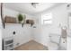 Laundry room features built-in shelf with baskets, toilet, and a small window for natural light at 1060 Haste Ln, Englewood, FL 34223