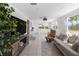 Spacious living room filled with natural light from two windows and featuring a comfortable sofa and a large screen TV at 1060 Haste Ln, Englewood, FL 34223