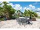 Brick patio features an outdoor dining area with an iron table and six chairs under a bright sunny sky at 1060 Haste Ln, Englewood, FL 34223