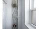 Walk-in shower showcasing modern tile design, a rainfall shower head, and a window for natural light at 1060 Haste Ln, Englewood, FL 34223