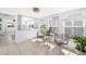 Sun room features a cozy sitting area with wicker chairs, ample natural light from multiple windows, and tile flooring at 1060 Haste Ln, Englewood, FL 34223