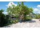 Beautiful view of the canal from brick patio, accentuated by a lush tree, shrubs, and a blue decorative pot at 1060 Haste Ln, Englewood, FL 34223