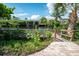 A quaint wooden walkway leads to a private dock on the canal, framed by palm trees and lush greenery at 1060 Haste Ln, Englewood, FL 34223
