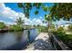 Scenic canal view from a weathered dock, featuring a charming waterfront home surrounded by lush foliage at 1060 Haste Ln, Englewood, FL 34223