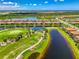 Gorgeous aerial view of houses on the water with a golf course in the foreground and blue skies above at 10788 Tarflower Dr # 201, Venice, FL 34293