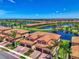 Lovely aerial view showcasing the property's location and the community's lush greenery, a lake, and golf course at 10788 Tarflower Dr # 201, Venice, FL 34293