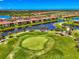Stunning aerial view of houses lining the water and golf course with vibrant blue skies and scattered clouds at 10788 Tarflower Dr # 201, Venice, FL 34293