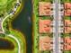 Aerial shot of houses with red roofs lining a golf course and lake, adjacent to a residential street at 10788 Tarflower Dr # 201, Venice, FL 34293