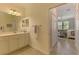 Bathroom showcasing a vanity with ample storage, a mirror, and a view into the Primary bedroom at 10788 Tarflower Dr # 201, Venice, FL 34293