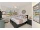 Serene bedroom with a ceiling fan, king bed, a large window and a neutral decor palette at 10788 Tarflower Dr # 201, Venice, FL 34293