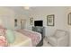 Well-lit bedroom featuring a ceiling fan, king bed, accent chair, and neutral decor, with attached bathroom access at 10788 Tarflower Dr # 201, Venice, FL 34293