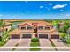 Beautiful Mediterranean-style villa with a clay tile roof, paver driveway, and lush landscaping at 10788 Tarflower Dr # 201, Venice, FL 34293