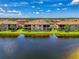 Exterior view of a home, complete with a screened lanai, overlooking a serene lake at 10788 Tarflower Dr # 201, Venice, FL 34293