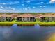 Exterior view of a home, complete with a screened lanai, overlooking a serene lake at 10788 Tarflower Dr # 201, Venice, FL 34293